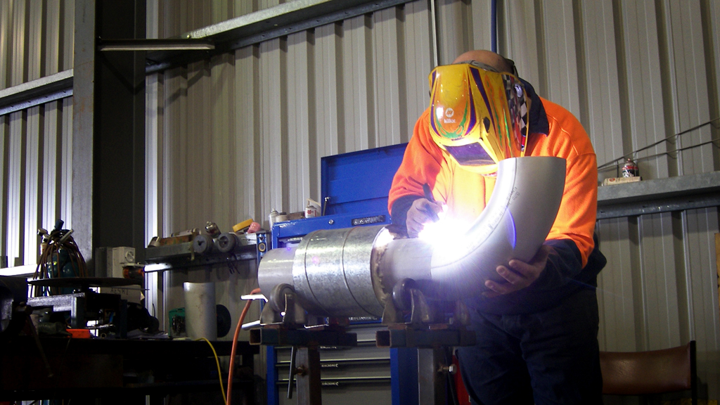 Equipped man welding a pipe
